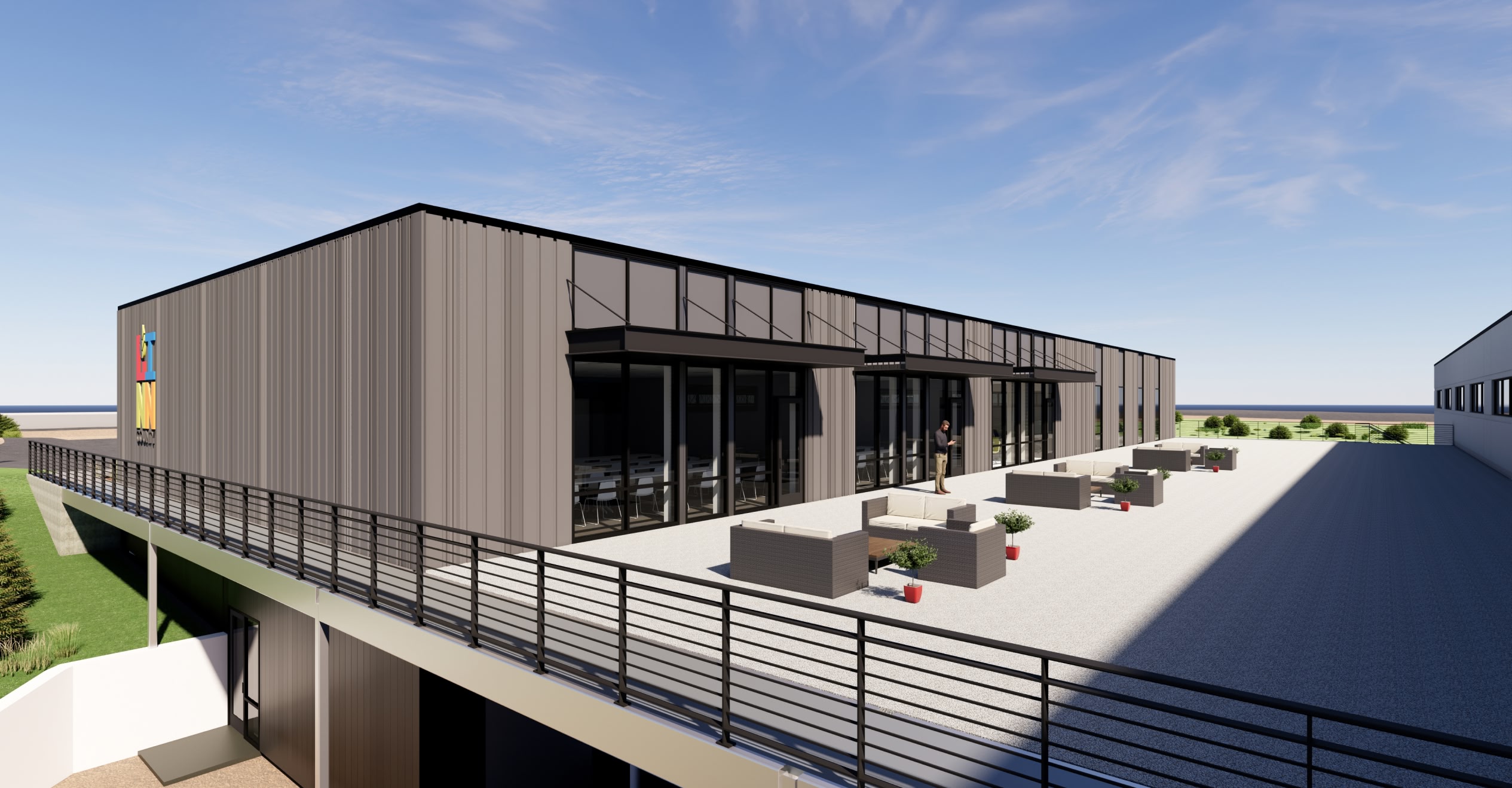 Modern building with large glass windows and a spacious outdoor patio featuring minimalist furniture