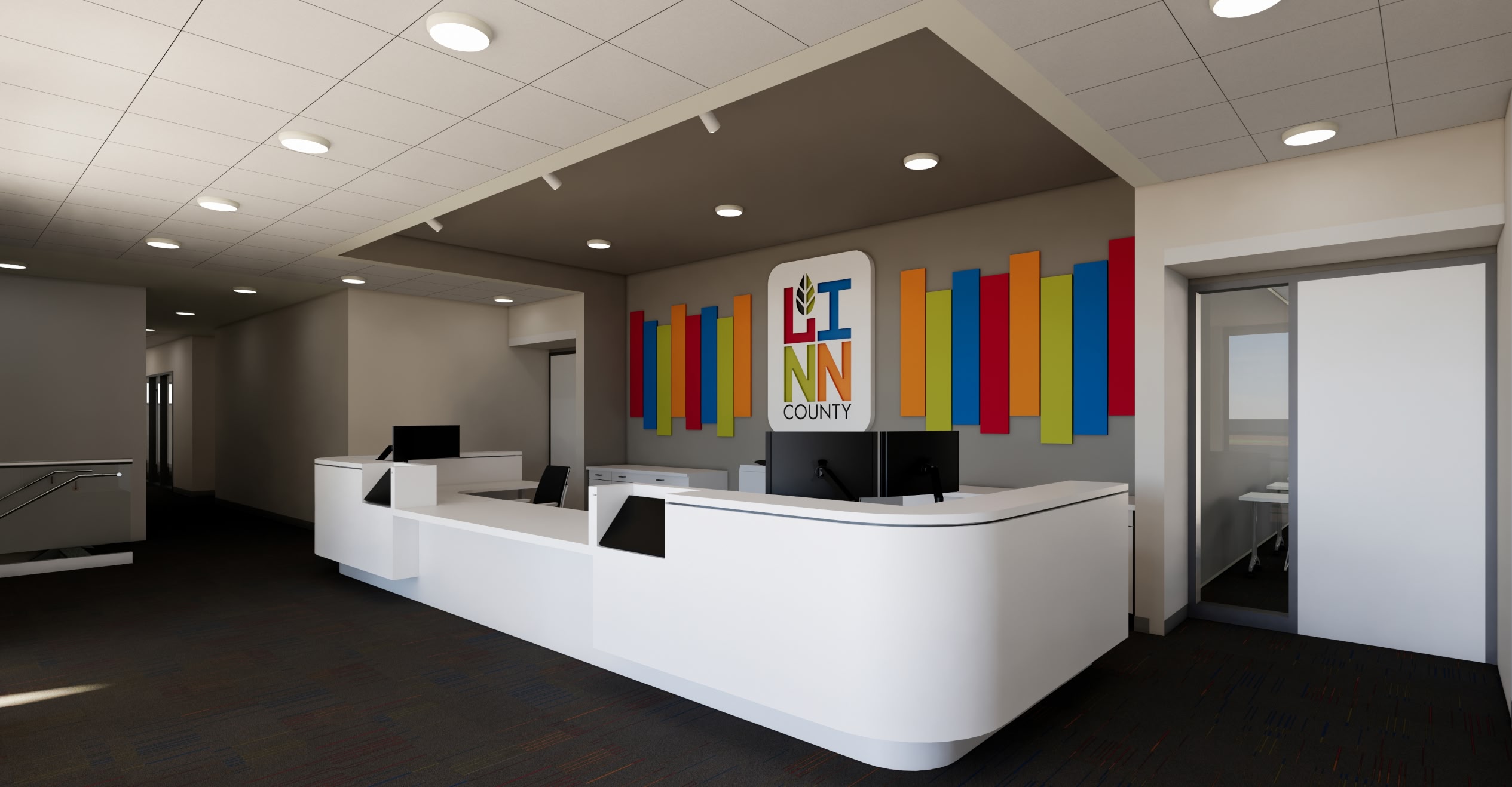 A modern reception area with two white curved desks, black monitors, and a colorful wall design. Bright, welcoming atmosphere with overhead lighting.