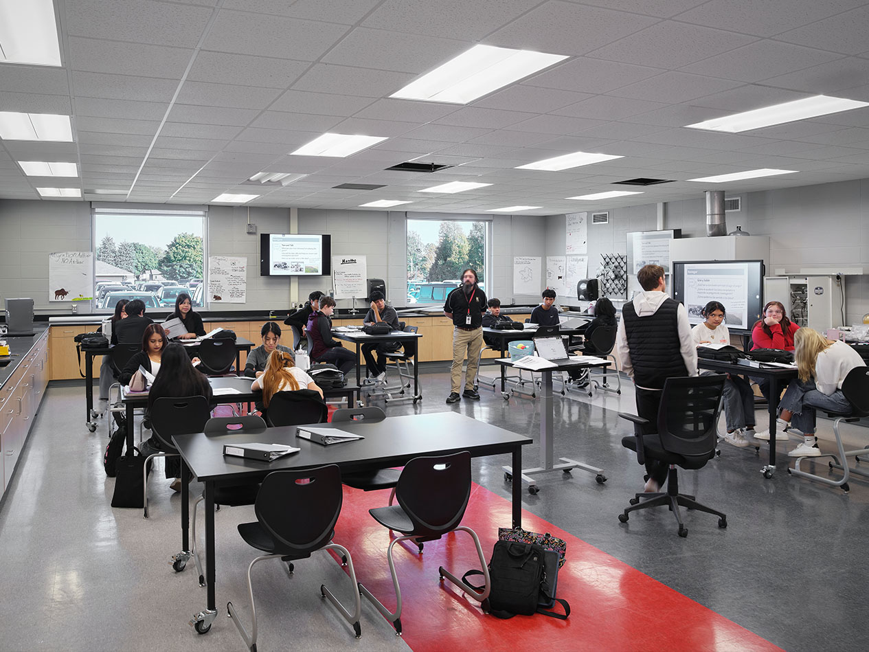 Flexible classroom with movable desks, technology, and students working collaboratively.