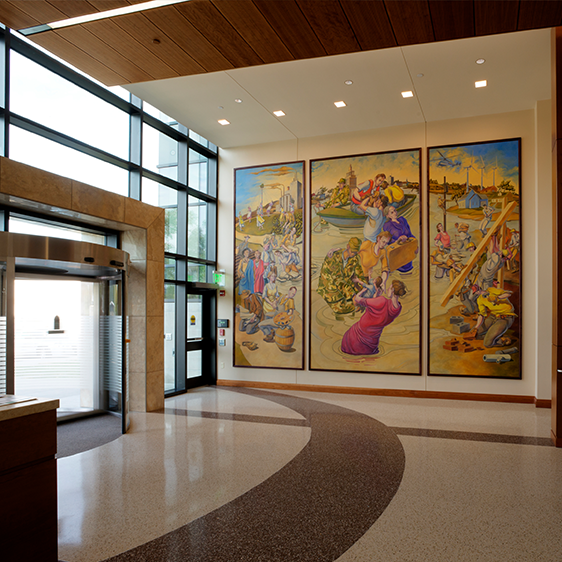 Light-filled interior lobby of the Jean Oxley Public Service Center showcasing a large public art installation, wood ceilings, and clear circulation paths.
