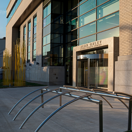 Exterior entrance of the Jean Oxley Public Service Center with glass facade, stone cladding, and accessible handrails leading to the main