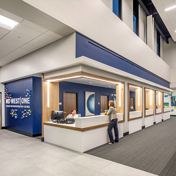 nterior lobby of the MD West One Fountain Ridge medical office building with reception desk, wood finishes, and clear wayfinding signage.