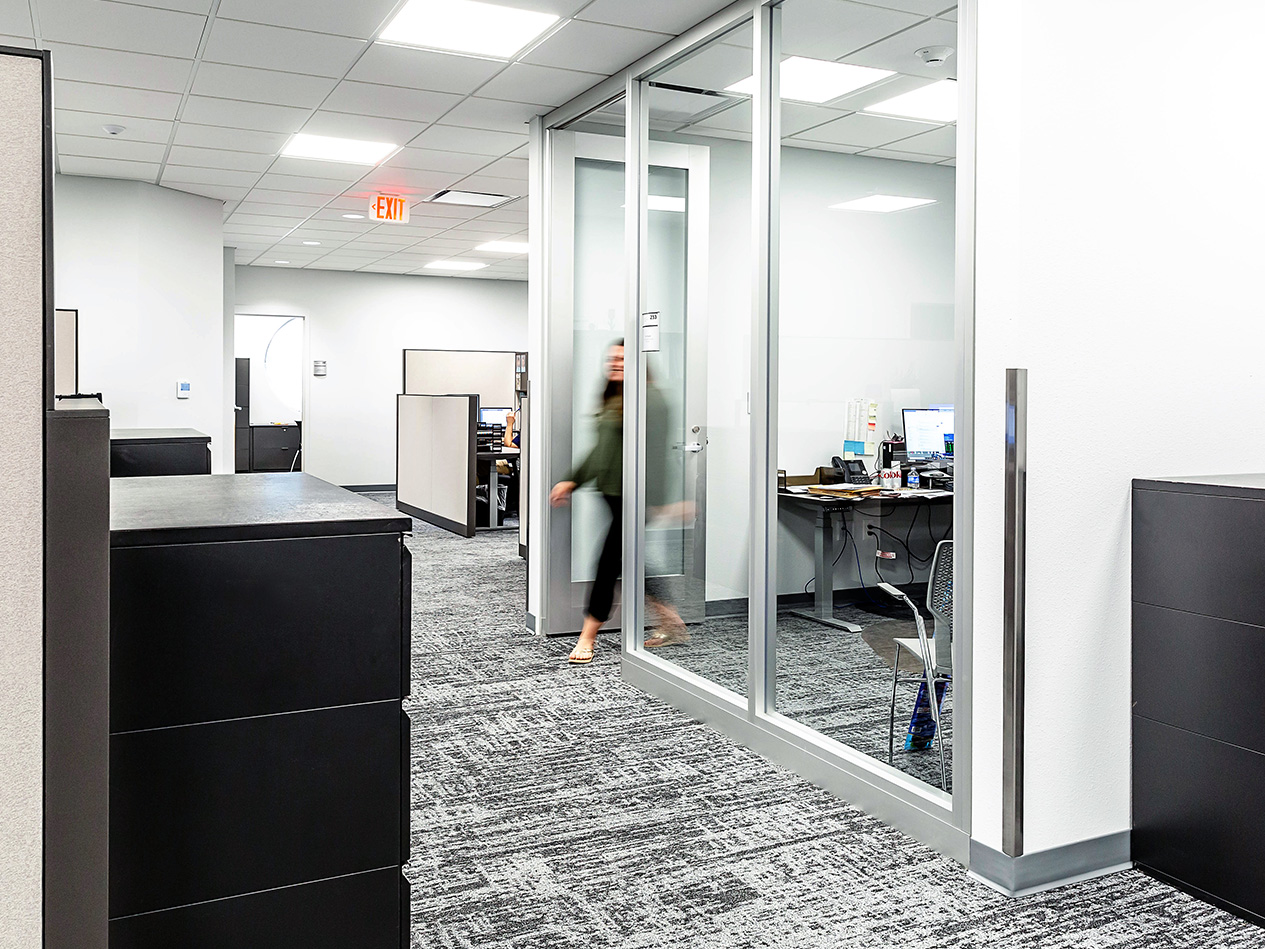 Office workspace at Cedar Falls City Hall with glass partitions and collaborative layout.