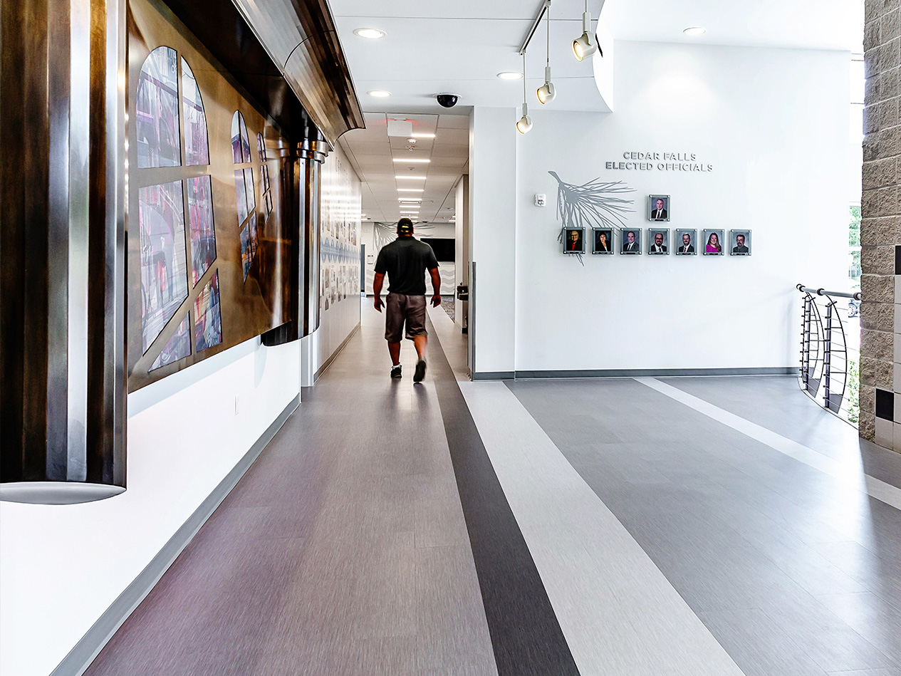 Renovated hallway at Cedar Falls City Hall featuring clear wayfinding and gallery-style displays.