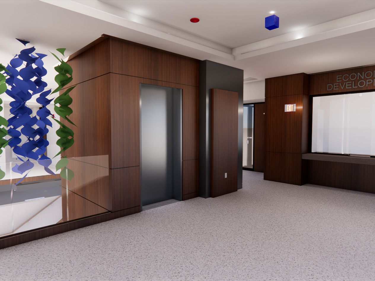 Interior of the Cedar Rapids Annex Building showing wood-paneled elevator cores, terrazzo flooring, sculptural wall art, and a reception area near the Economic Development office with clear wayfinding and modern finishes.