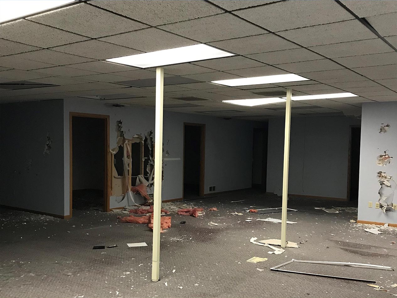 Interior of the former Colonial Centre before renovation, showing a deteriorated space with damaged ceilings, exposed supports, and unfinished surfaces prior to conversion into The Heights affordable housing community.