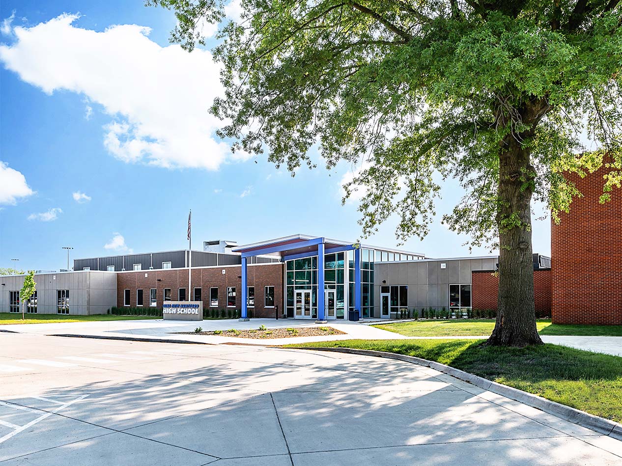 Dike-New Hartford school exterior with blue metal siding, brick walls, and main entrance canopy.