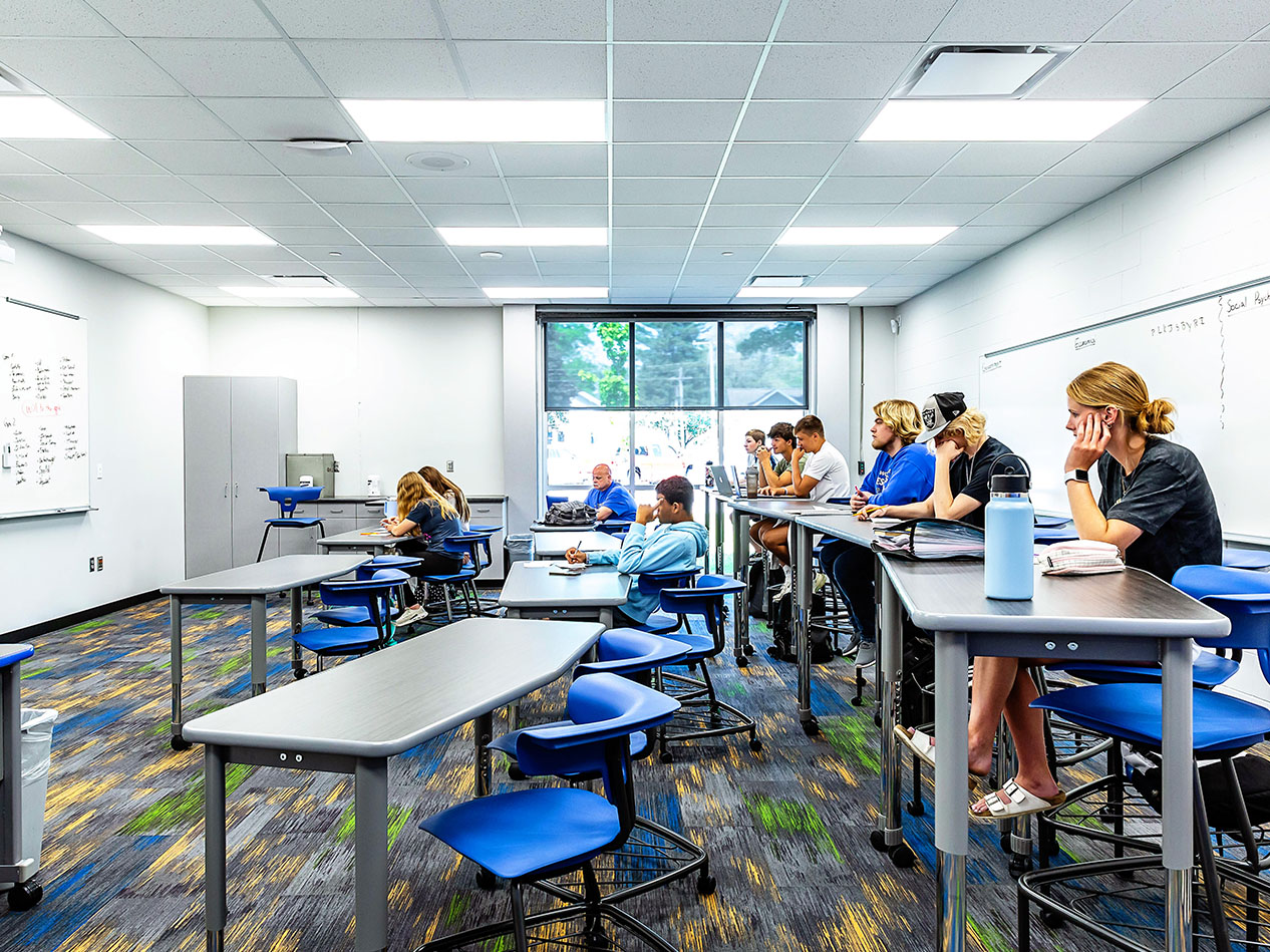 Classroom with students working at tables in a bright learning space.