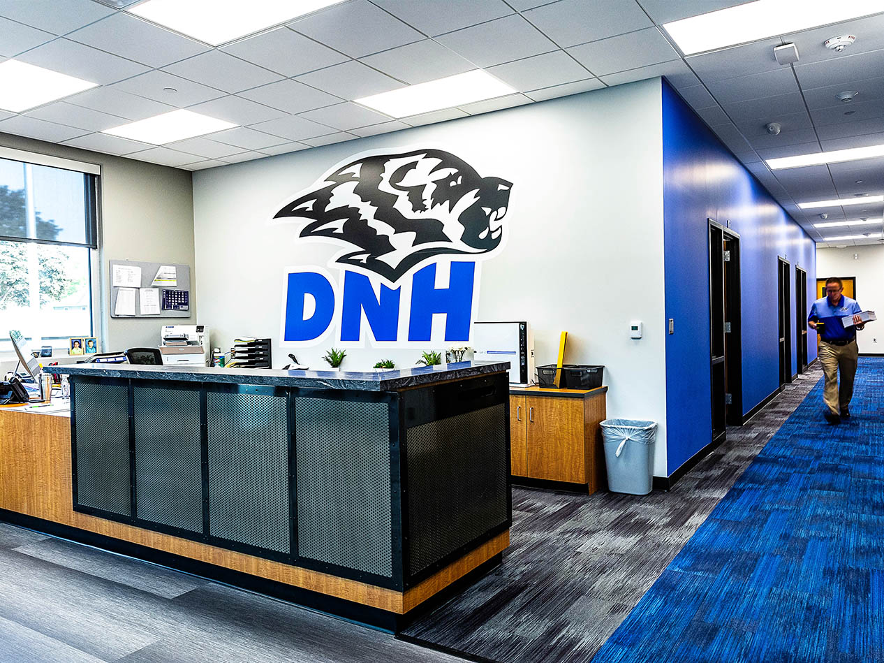 Dike-New Hartford reception area with large Wolverine logo wall graphic behind the front desk.