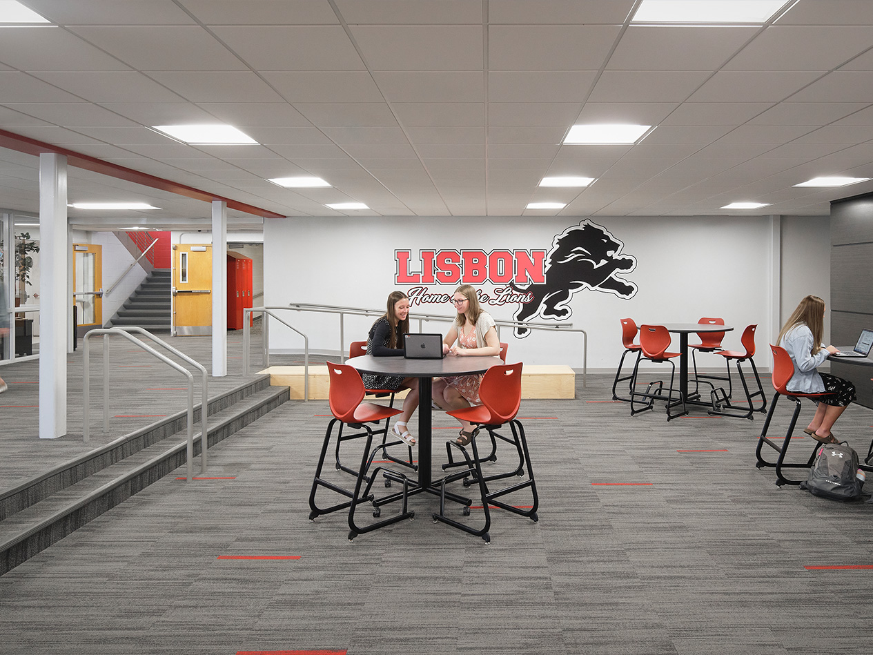 Flexible learning area with integrated seating and school branding to support informal student interaction.