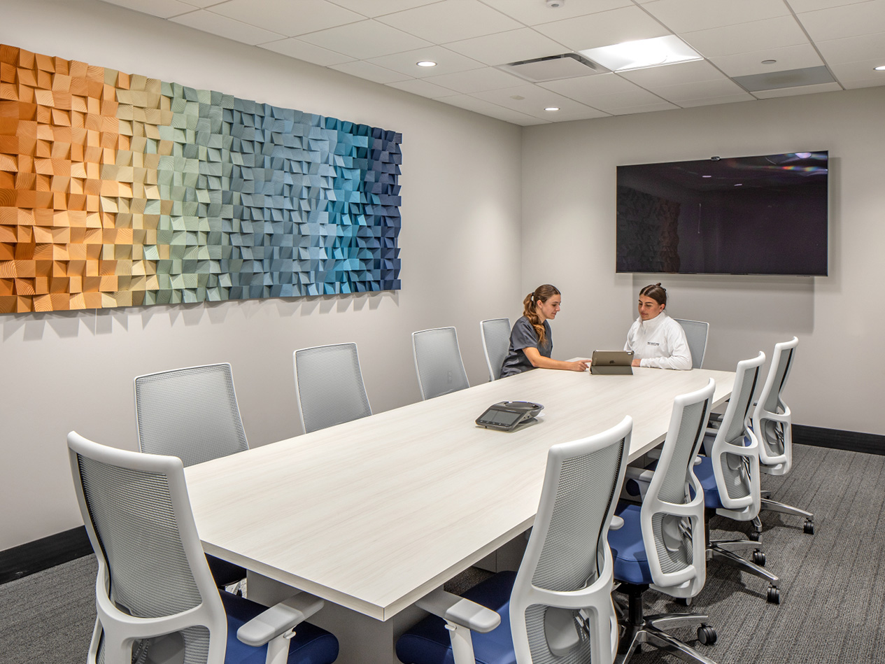 Conference room at MD West One Fountain Ridge with large meeting table, video display, and decorative wall feature.
