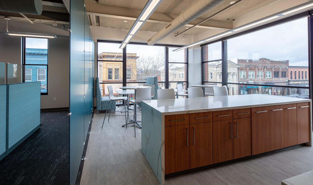 Office break room with large windows, gathering space, and views of downtown Cedar Falls at the 302 Main Street Building.