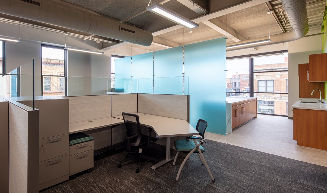 Open office workspace featuring private workstations, natural light, and contemporary finishes at the 302 Main Street Building.