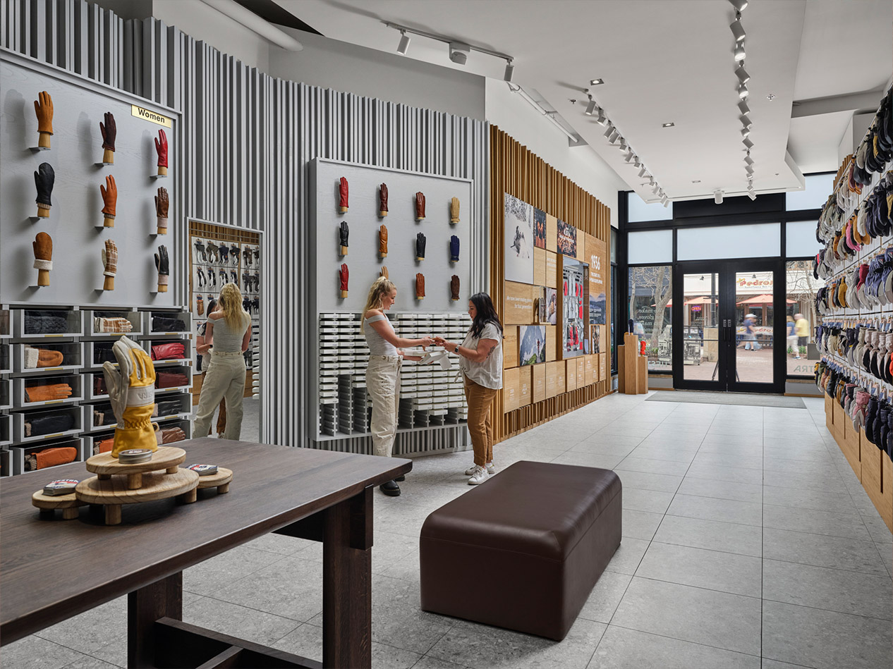 Hestra retail store design interior with customers viewing premium glove displays and Scandinavian-inspired merchandising