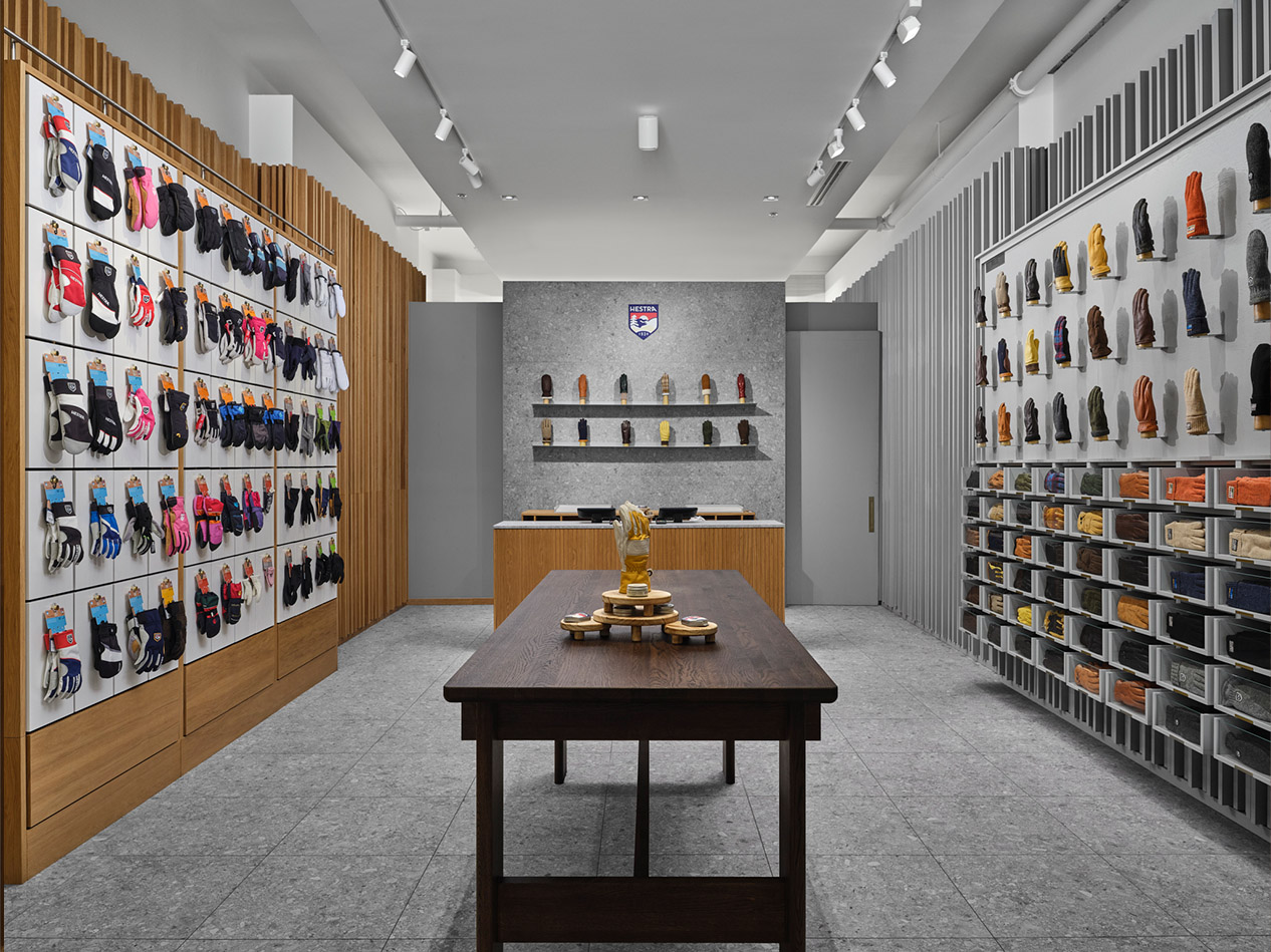 Hestra retail store design interior with symmetrical product displays and central merchandising table