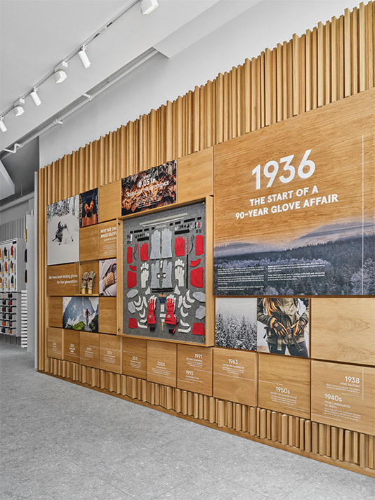Hestra retail store design detail wall showcasing brand history, product craftsmanship, and custom wood finishes