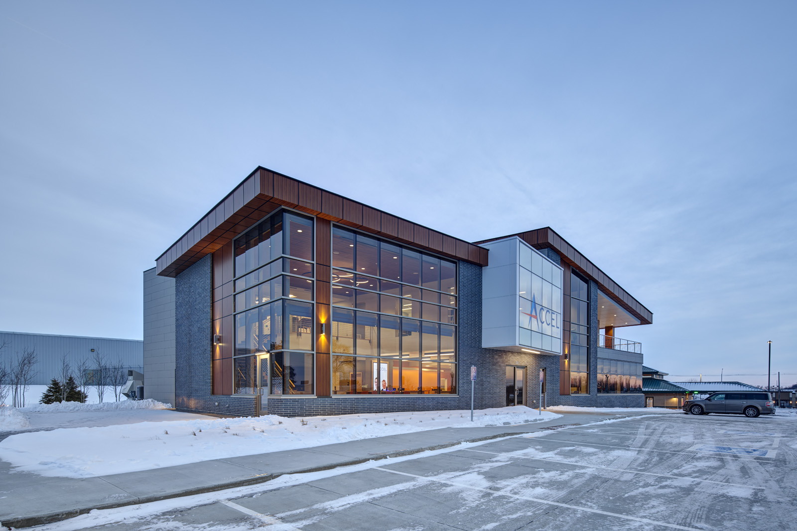 Corner exterior of The Accel Group headquarters showcasing glass curtain walls and contemporary office architecture.